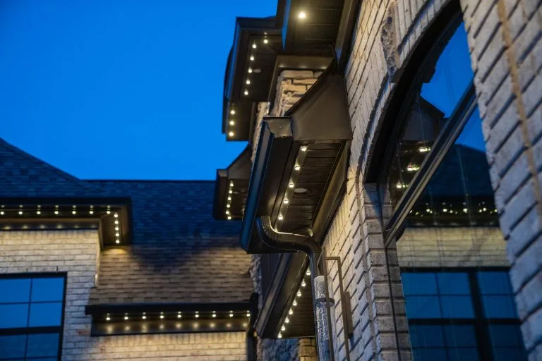 Warm lights illuminate the architectural details of a brick building at twilight