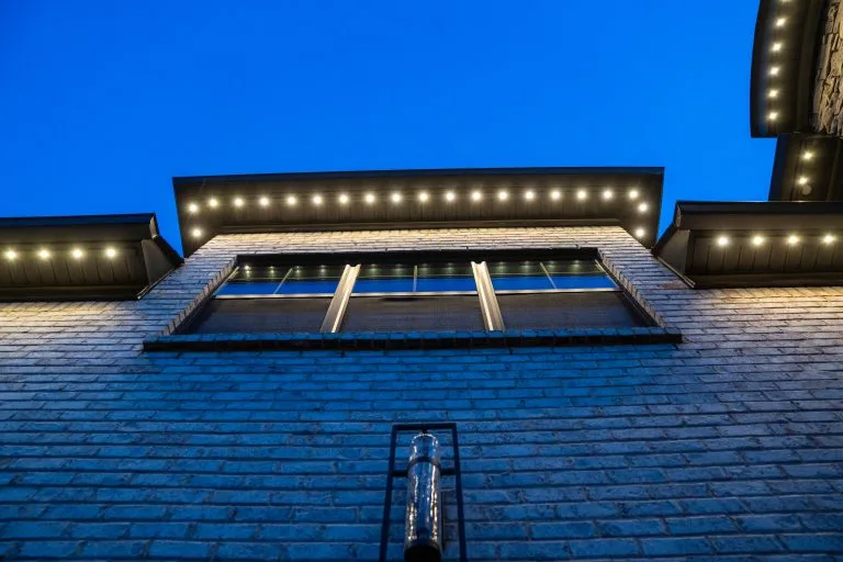 A bright, illuminated building glows against a deep blue evening sky