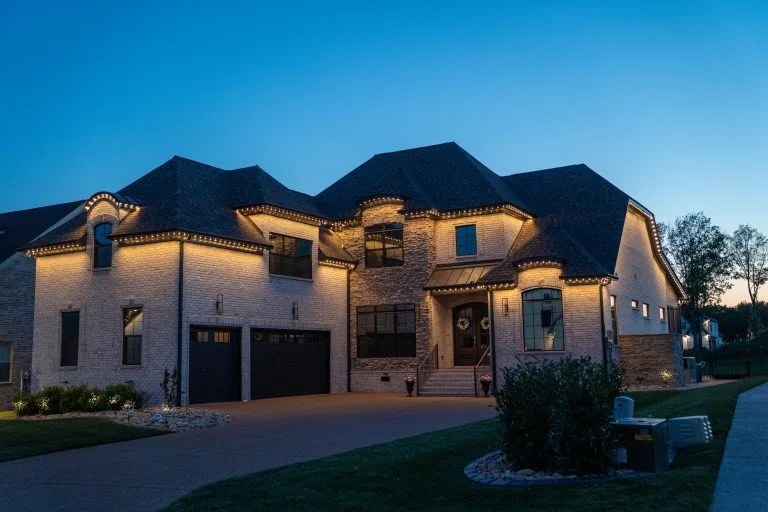 A beautifully lit, modern house stands out against a twilight sky