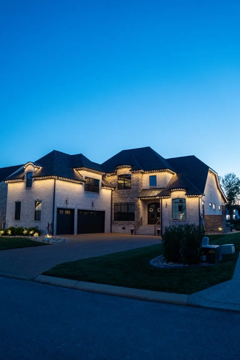 A beautifully lit house stands under a clear evening sky