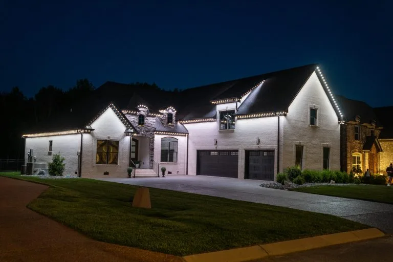 A beautifully illuminated modern house showcases decorative lighting against a dark night sky