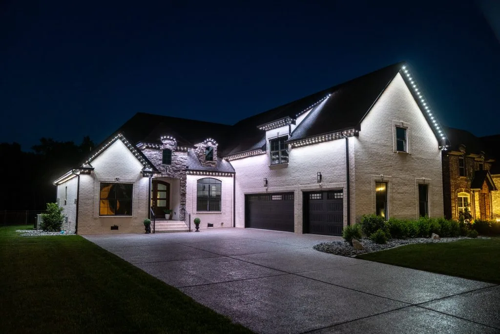 A beautifully lit modern house stands under a clear night sky