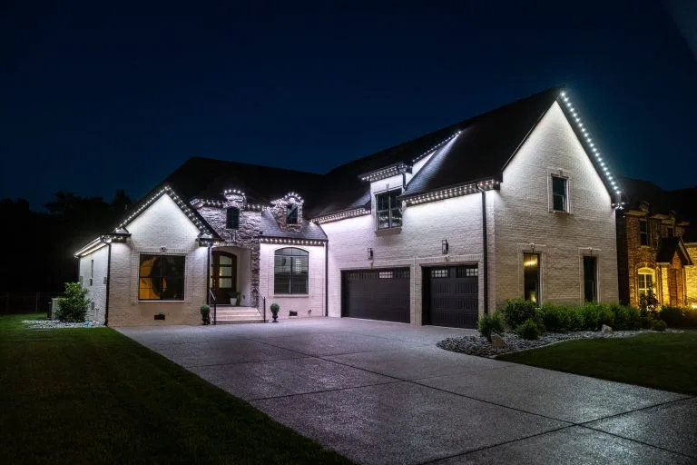 A beautifully lit modern house stands under a clear night sky