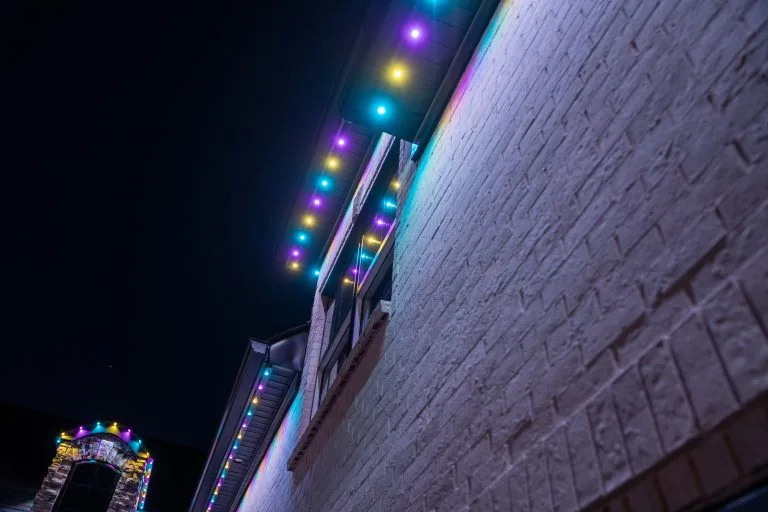 Colorful lights adorn the edge of a building, illuminating the night sky