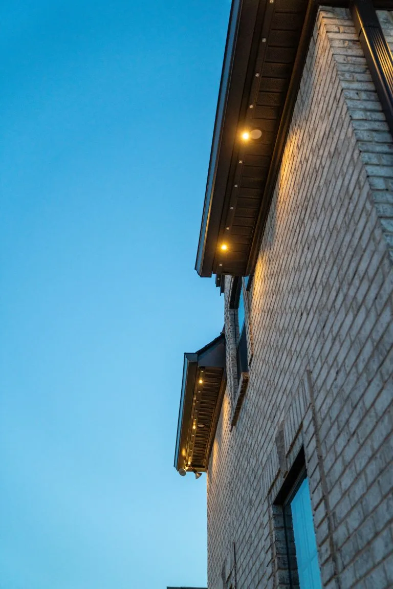 A building's corner is illuminated against a clear evening sky