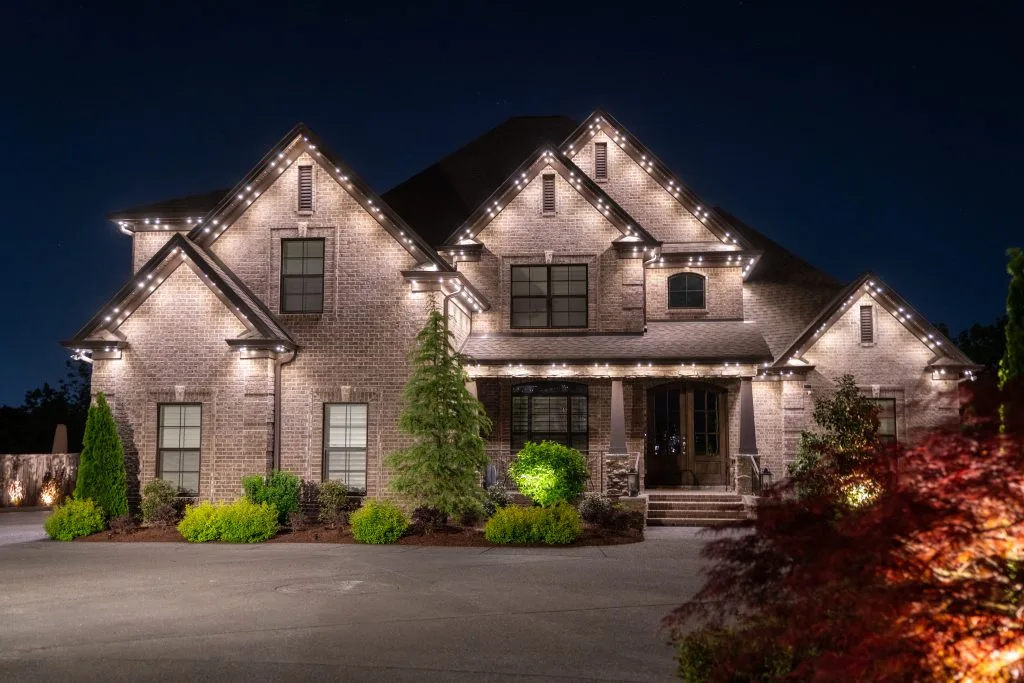 A beautifully lit home showcases elegant architecture against a dark night sky