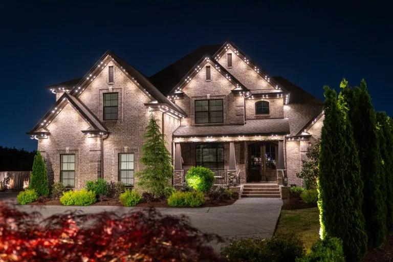 A beautifully lit home showcases decorative lights around its elegant facade at night