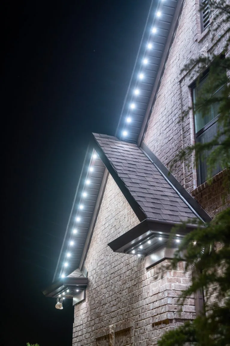Bright LED lights illuminate the edges of a house's roof at night
