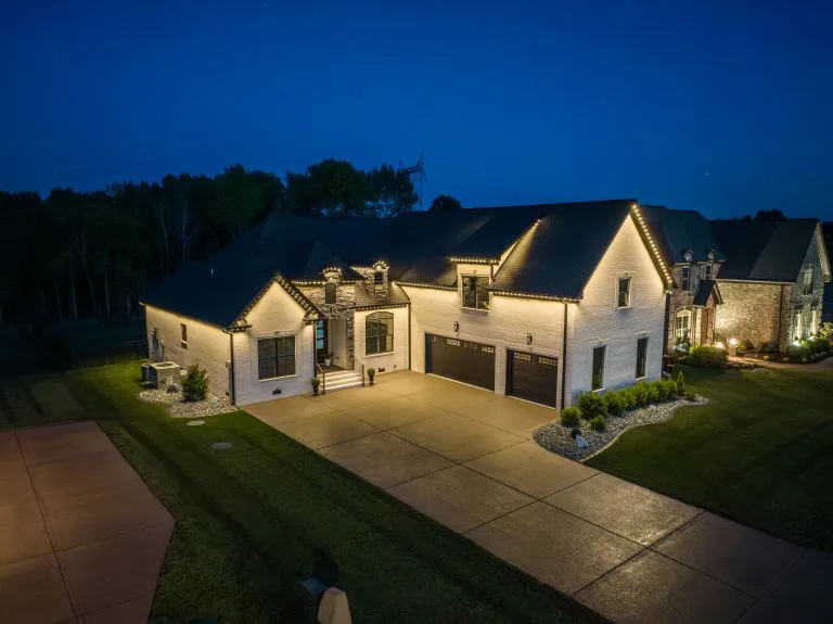 A beautifully lit home stands under a twilight sky, showcasing its elegant architecture