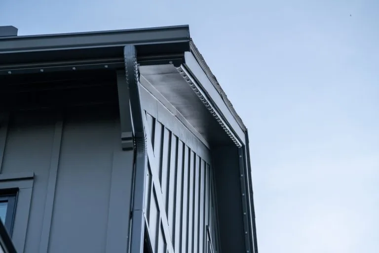 A sharp-edged roofline contrasts against a clear blue sky