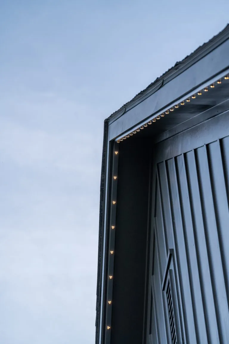 A roofline meets a cloudy sky, showcasing architectural lines and subtle lighting