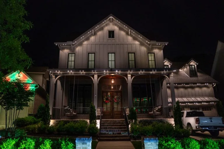 A beautifully lit house adorned with festive decorations stands out against the night sky