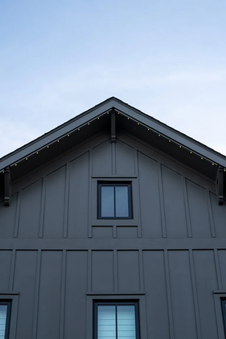 A modern house with a pointed roof and large windows under a clear sky
