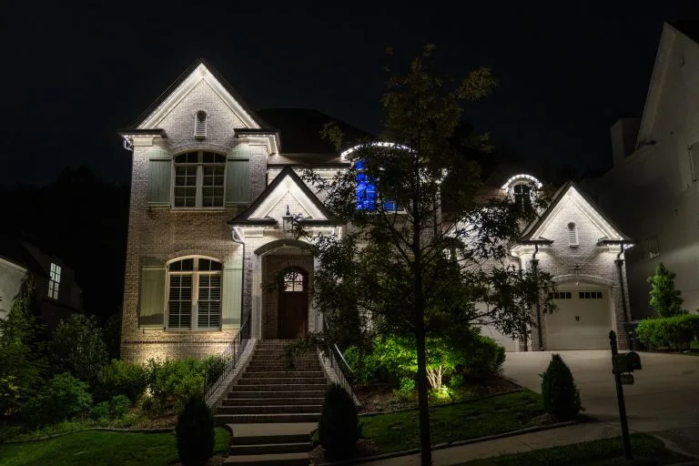 A beautifully lit elegant house stands out against the night sky