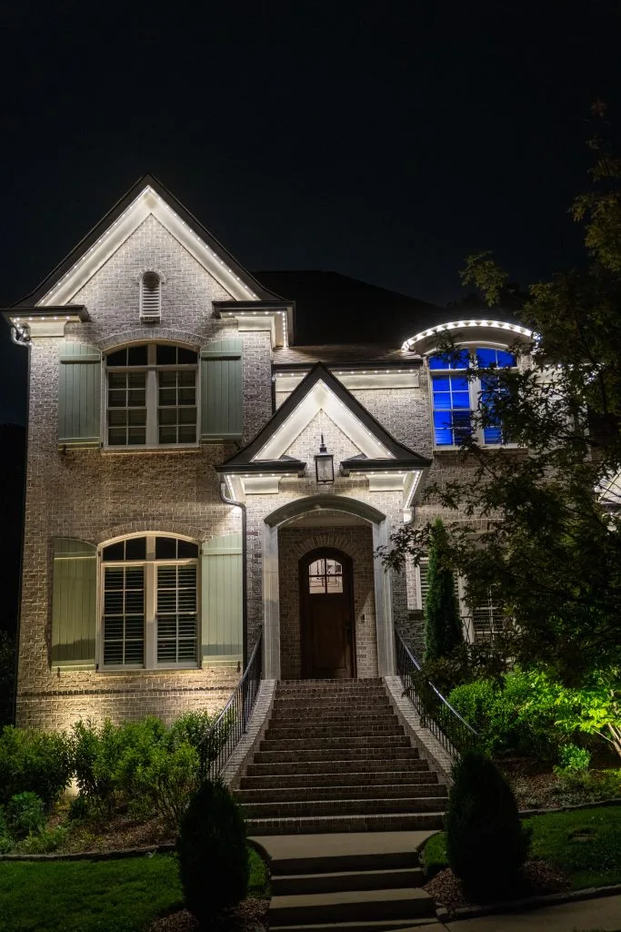 A beautifully illuminated house stands out against the night sky, showcasing elegant architectural details