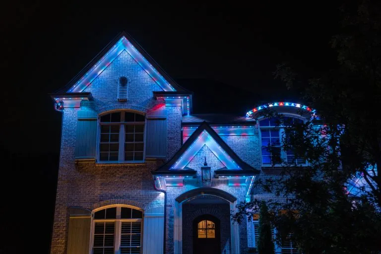 A house is beautifully illuminated with colorful lights against a dark night sky