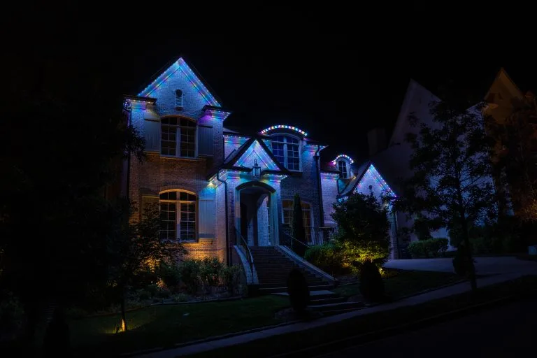 A beautifully lit house sparkles with colorful lights against a dark night sky
