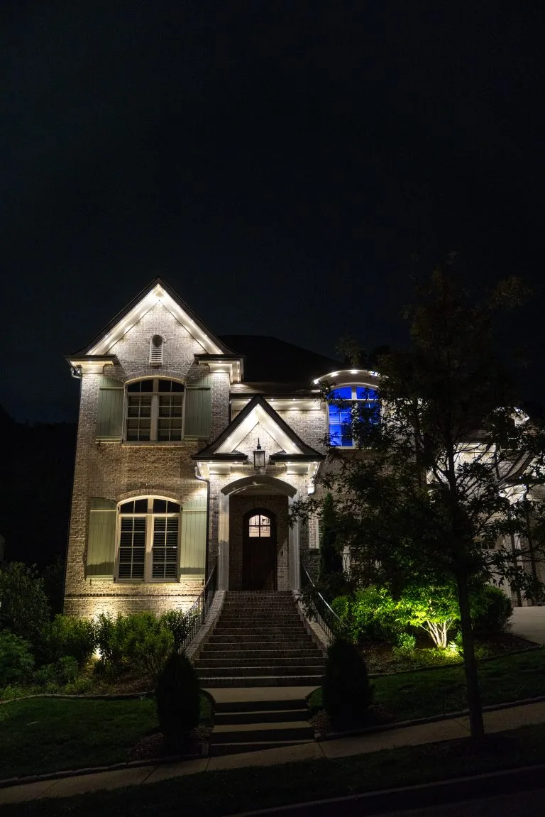 A beautifully lit house stands out against the dark night sky