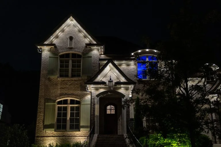 A beautifully illuminated house at night showcases its architectural features
