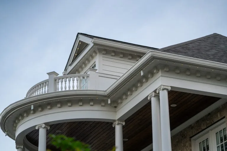 A modern house showcases elegant architectural details and stylish columns under a clear sky