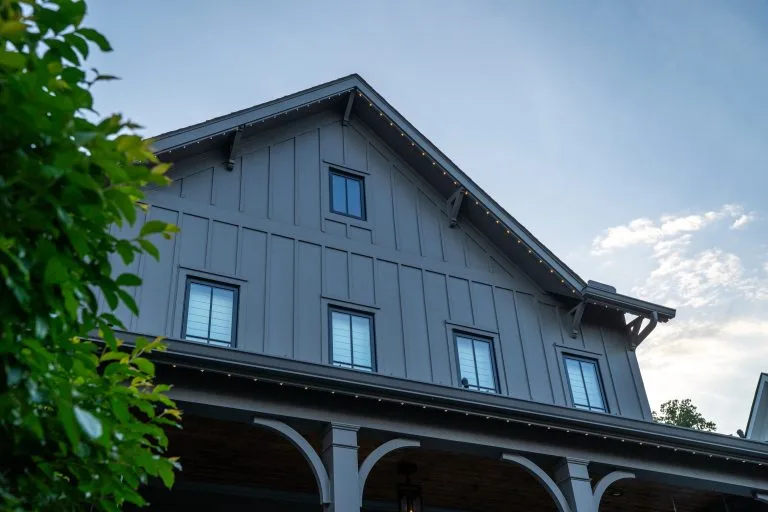 A stylish house features a sloped roof under a blue sky with scattered clouds