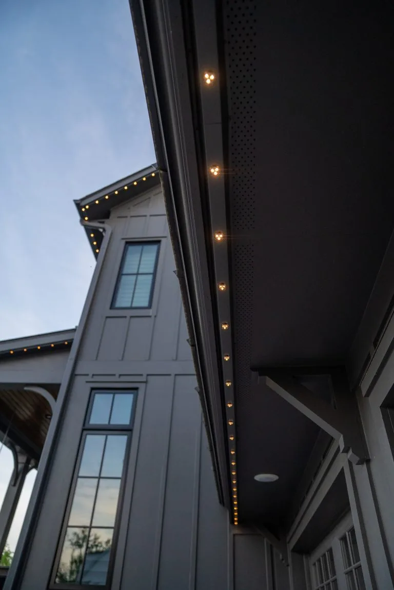 Soft lights adorn the edge of a modern house under a clear sky