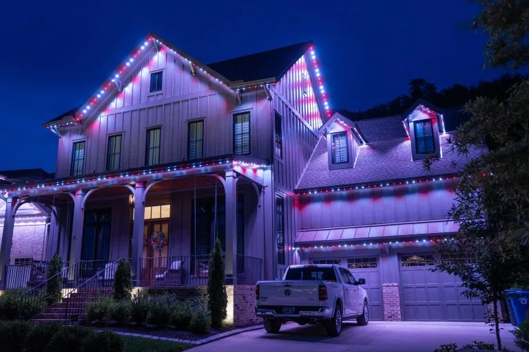 A beautifully decorated house is illuminated with colorful lights at night