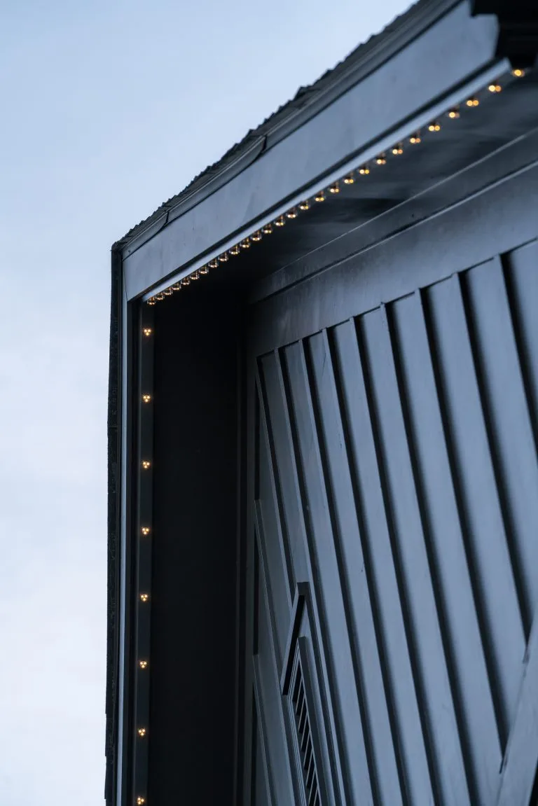 A modern building features a sharply angled roof with subtle lighting