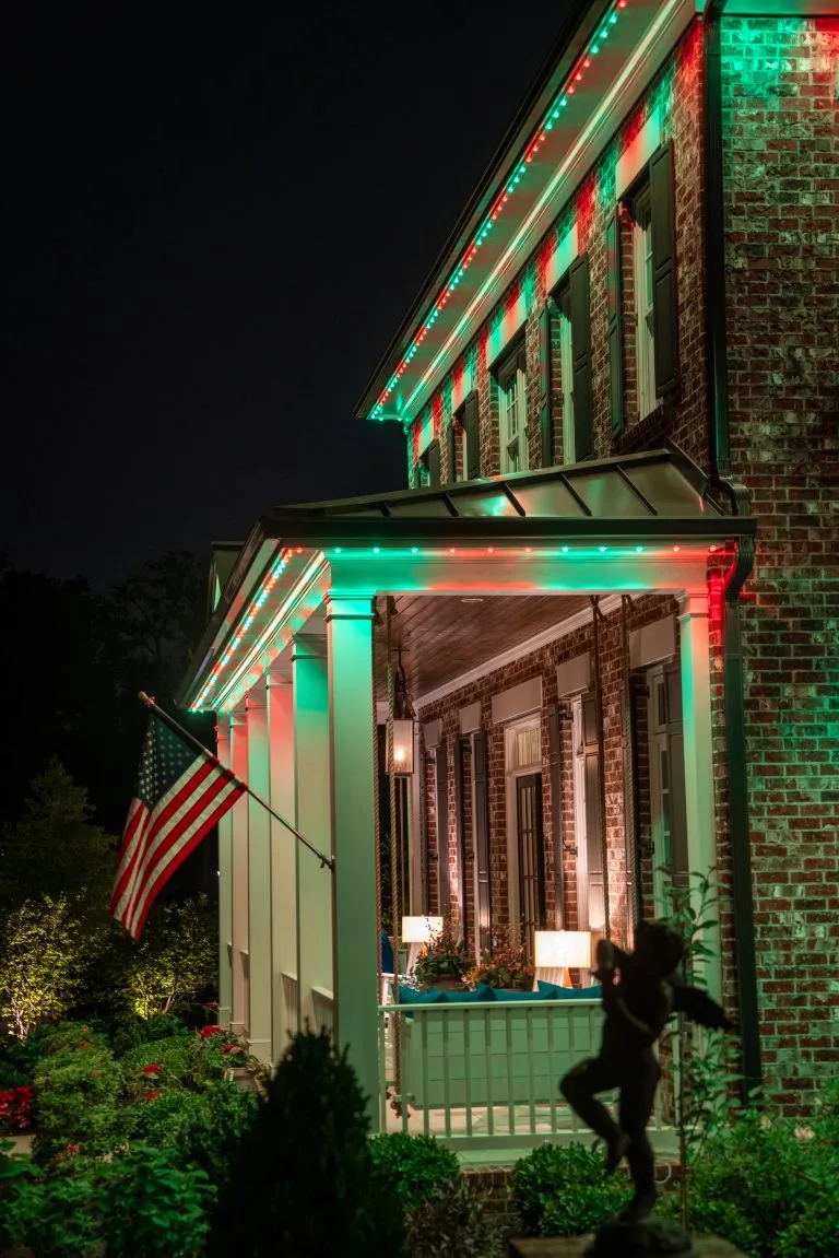 A house is illuminated with festive red and green lights at night