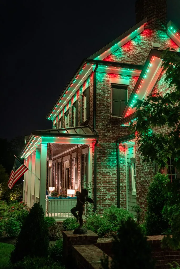 Permanent Christmas lights near Grant Park Atlanta brighten a house with festive red and green colors at night