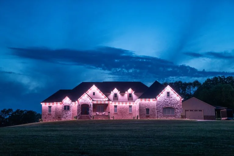 A beautifully lit stone house stands against a vibrant twilight sky