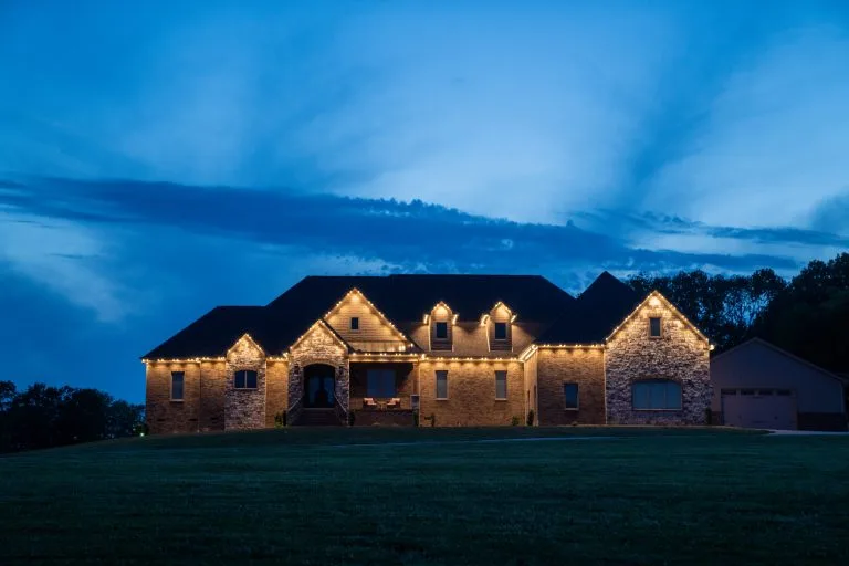 A beautifully lit stone house glows under a twilight sky