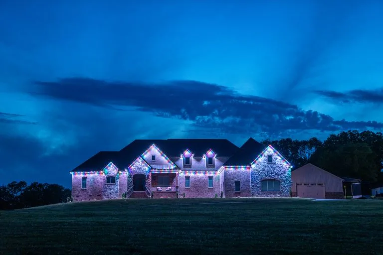 A beautifully lit house stands against a dramatic twilight sky