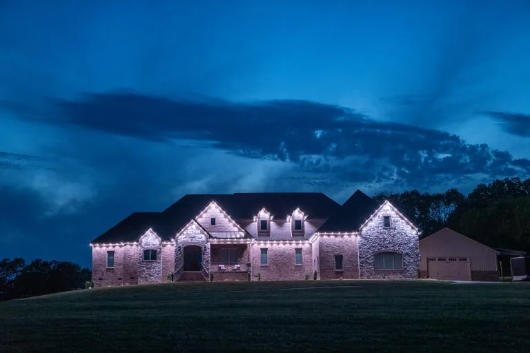 A beautifully lit house stands against a dramatic twilight sky