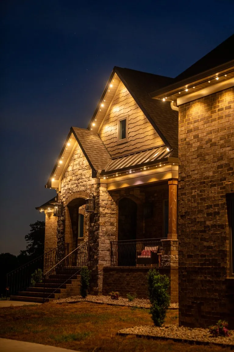 A charming home is illuminated by warm, glowing lights at night