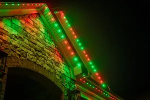 Commercial holiday lighting near Virginia-Highland Atlanta brightens a stone house with vibrant green and red lights