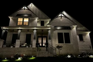 A well-lit modern house stands elegantly at night, showcasing its architectural details