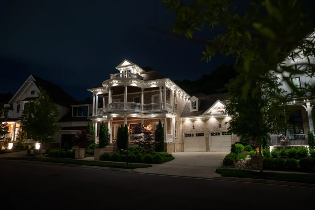 A beautifully illuminated house showcases elegant architecture against a dark night sky