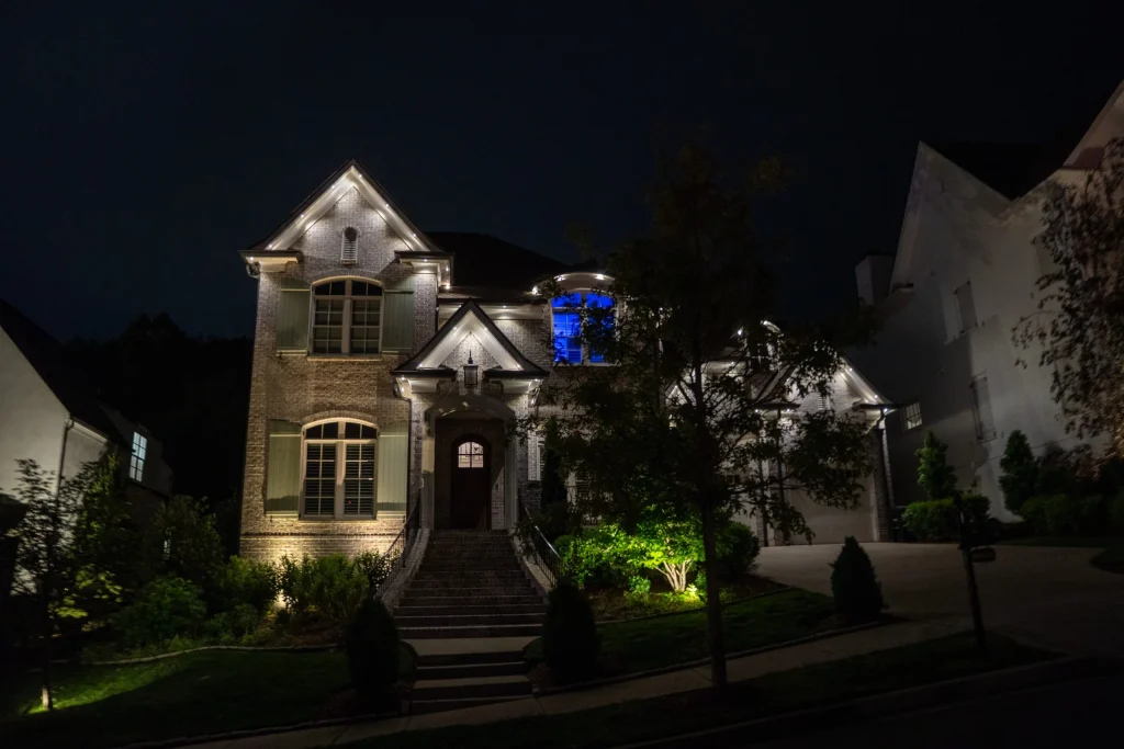 A beautifully illuminated house stands out against the dark night sky