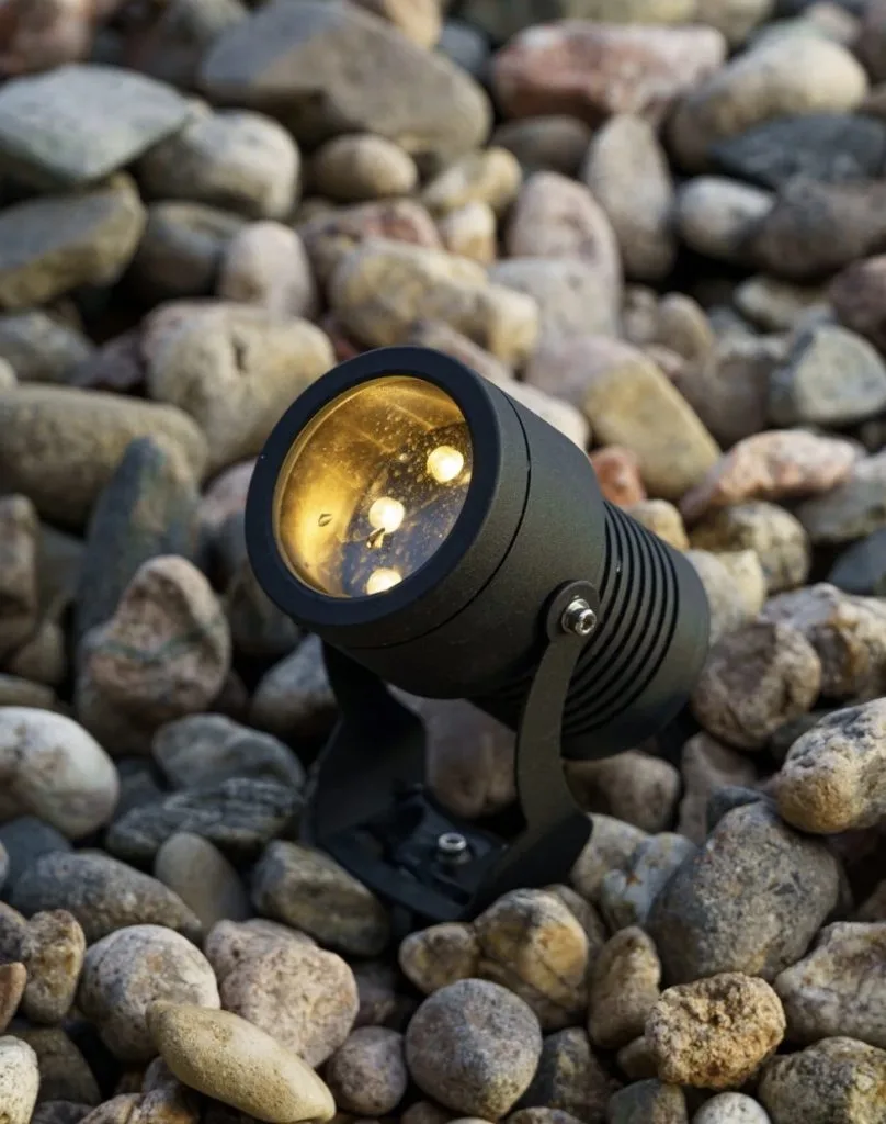 A spotlight illuminates a collection of smooth, assorted stones