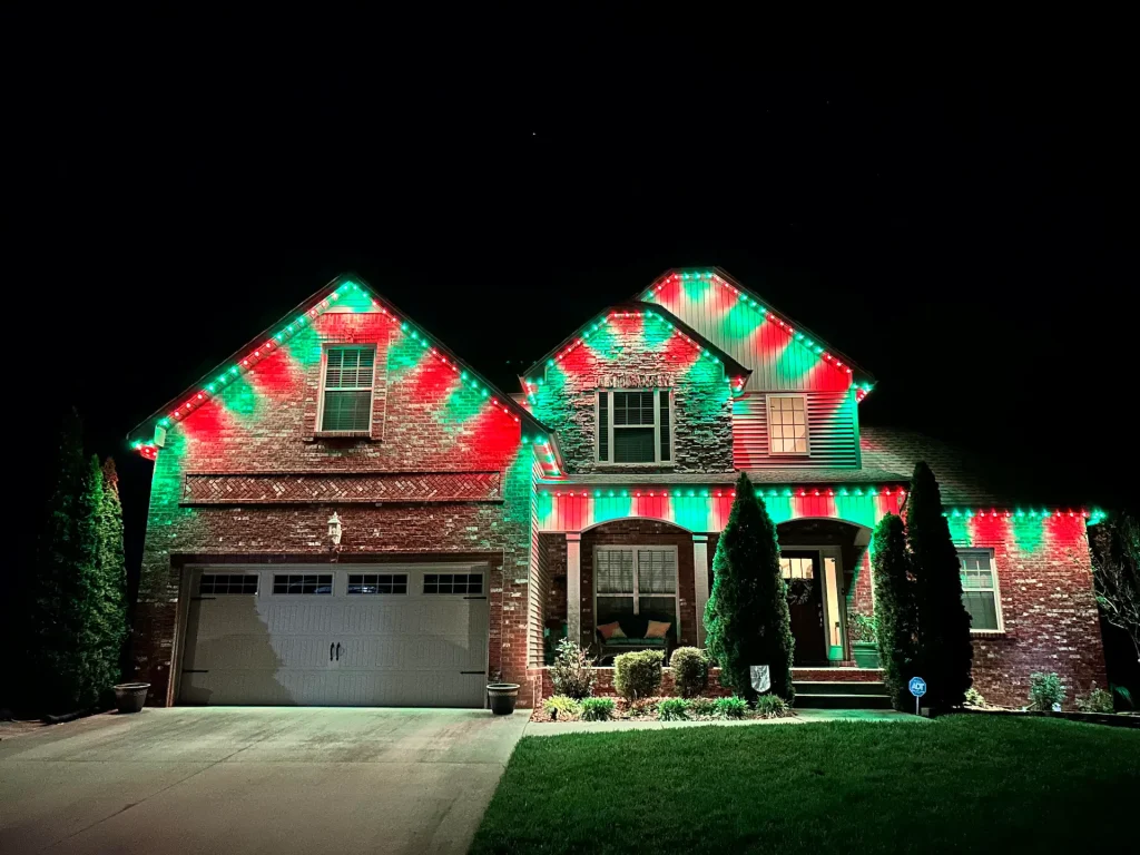 A festive landing page features a house adorned with vibrant red and green holiday lights
