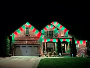 A festive landing page features a house adorned with vibrant red and green holiday lights