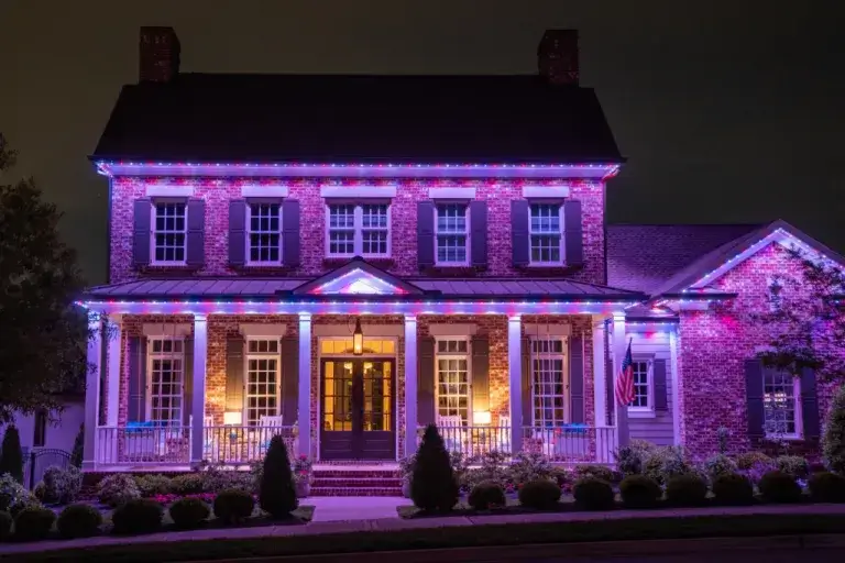 A beautifully decorated house glows with colorful lights at night